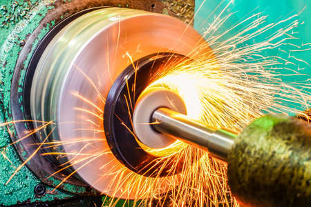 Production of parts in the metalworking industry, finishing on an internal steel surface grinding machine with flying sparksの写真素材