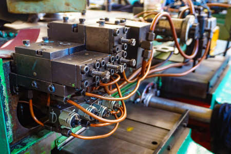 The hydraulic system on the machine, copper oil tubes connected to the equipment in production. Bed for guides under the influence of the hydraulic system. Abstract industrial backgroundの写真素材