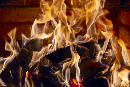 Burning firewood in the fireplace in the house, giving heat and heat. The concept of heating in the...