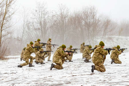 A combat squad in camouflage with a weapon goes on the offensive in winter.