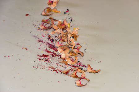 Chips of colored pencils lying on a white table, close-up.の写真素材