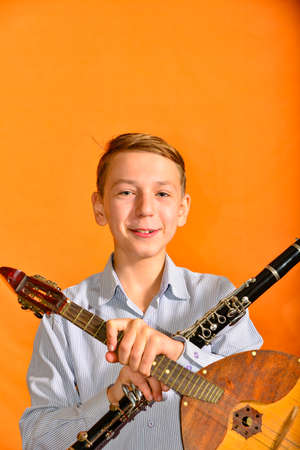 Boy holds dombra and clarinetの写真素材