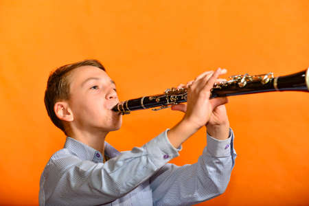 The boy performs a piece of music in the music school on the clarinet.の写真素材