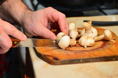 White mushroom is cut with a knife on a cutting board, concept of healthy nutrition.の写真素材