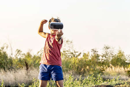 The boy in 3D glasses on the street in the park
