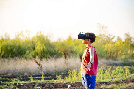 The boy in 3D glasses on the street in the park