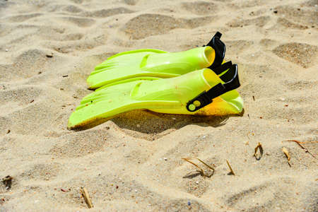 Yellow flippers for scuba diving lie on the sandの写真素材
