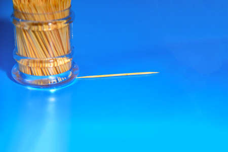 Toothpicks in plastic containers on a blue background.の写真素材