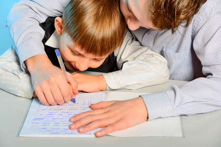 An older brother helps his younger brother do his homework.の写真素材