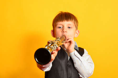 A little boy in a suit plays the clarinet.の写真素材