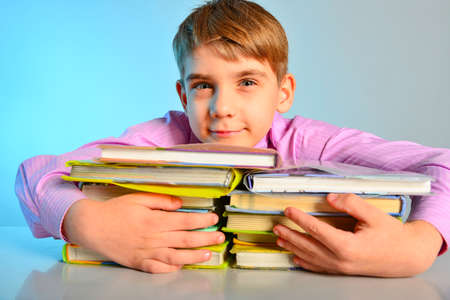 A student hugged textbooks with his hands, a joyful schoolboy loves to learn.