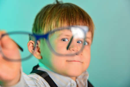 Portrait of a man through glasses, glasses in focus, the rest in blur.の写真素材