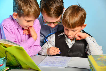Three students do school lessons together, solve homework tasks.