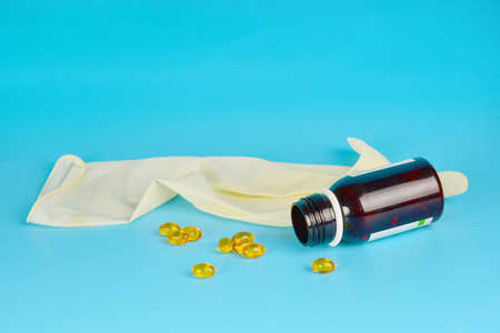 Medicine on a blue background, syringe, pills, medical gloves, ampoules and vials for use in...