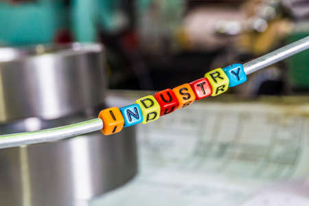 Industry of multicolored letters on the background of the drawings and turning and grinding parts at...