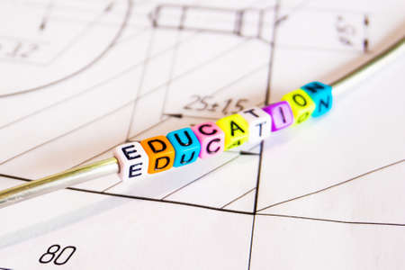 The inscription - the formation of multicolored letters on the background of technical drawings