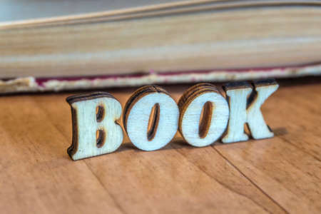 The inscription of wooden letters on the background of an old bookの写真素材