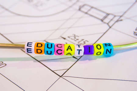 The inscription - the formation of multicolored letters on the background of technical drawingsの写真素材