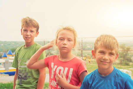 Tired children in an extreme park after a walk, a sister and two brothers are resting after a hard...