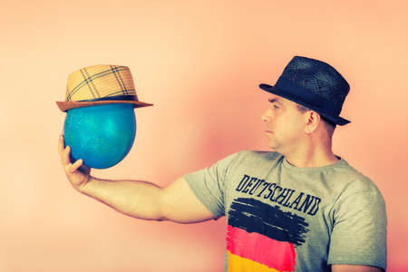 A man in a straw hat holds a balloon in his hand in a hat, concept of friendship with an imagined...