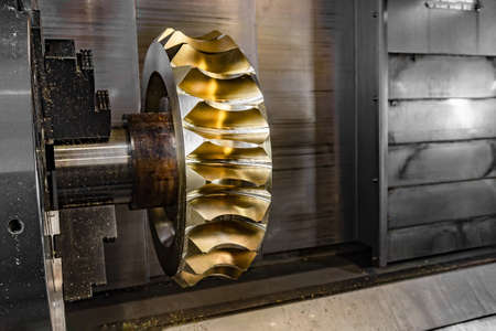 Gear processing on a CNC machine made of bronze, close-up gear cutting production.