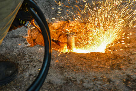 Gas cutting in industrial production and metallurgy, worker cuts metal with a gas torch and oxygen.