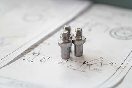 Detail after turning with thread on the background of technical drawings.