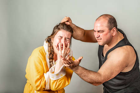 Husband strangles and beats his wife, family conflicts in the form of staged. The concept of social problems within the family.の写真素材