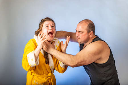 Husband strangles and beats his wife, family conflicts in the form of staged. The concept of social problems within the family.の写真素材