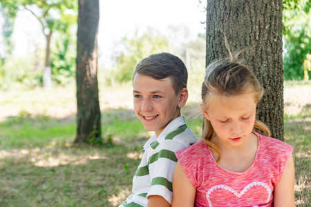 A boy and a girl do their homework in the park and get ready for school together.の写真素材