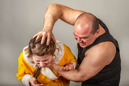 Husband strangles and beats his wife, family conflicts in the form of staged. The concept of social problems within the family.の写真素材