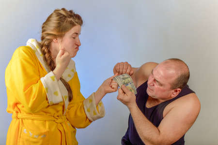 A wife beats her husband and takes money from him, the concept of social problems in families.の写真素材
