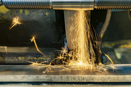 Grinding a threaded shaft on a circular grinding machine with sparks.