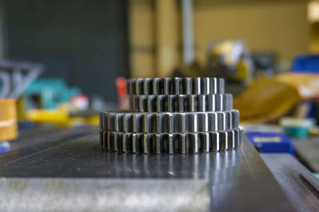 A gear disk with the number of teeth of a metalworking machine lies in the workshop on a guide bed.