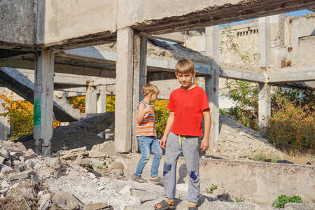 Two poor and dirty children are looking for food and shelter in the trash.の写真素材