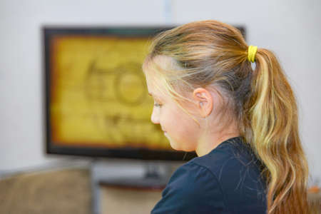 Young girl watching tv in a relaxation room.の写真素材