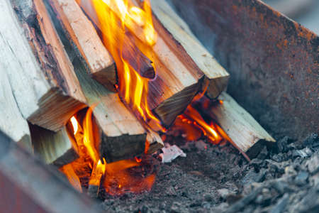 Burning logs for kindling a fire, flame and smoke on fire. Logs in a barbecue for frying meat.