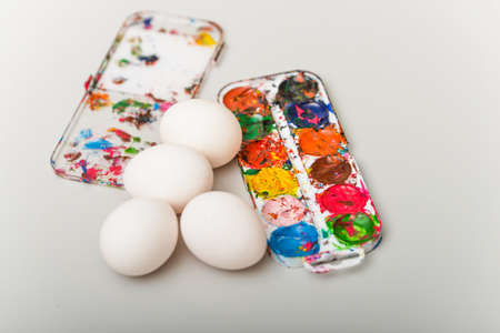 White eggs with paints lie on the table for the Easter holiday.の写真素材