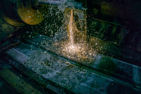 Grinding machine for metal processing with abrasive tools in production with cooling and sparks.の写真素材