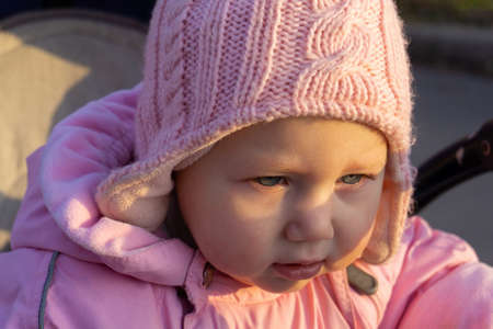 A little girl with tears crying in a pram.
