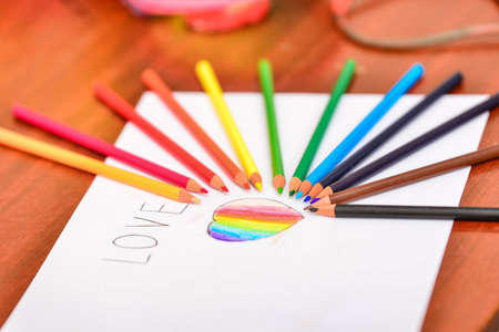 Drawn heart and the inscription "love" colored pencils on a white sheet.の写真素材