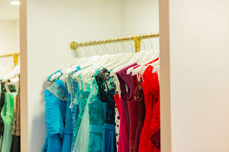 Evening elegant dresses on a shop window of a fashion boutique and on a hanger of a store for sale.の写真素材