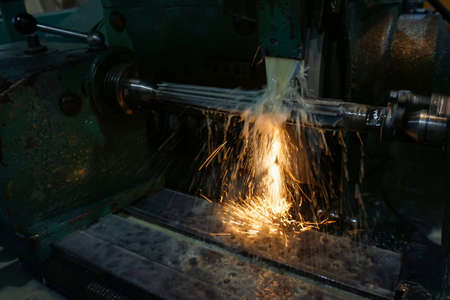 Grinding and high-precision shaft processing on a circular grinding machine with sparks and coolingの写真素材