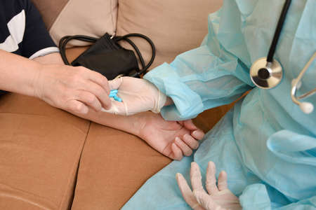 A sick patient takes medicine and pills from the hands of the attending physician
