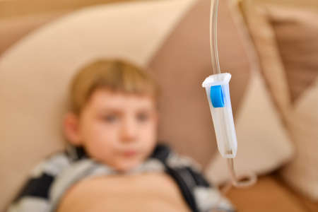 The child at home lies under a dropper, injections to the child with an infectious diseaseの写真素材