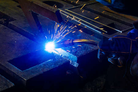 Welder at work in the workshop, welding products semi-automatic