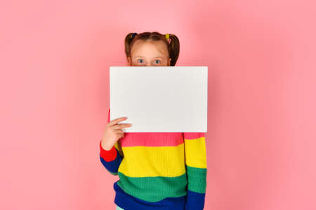 Girl holding a blank poster for inscription and text.