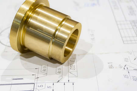 The bronze mandrel after grinding and turning lies on the technical drawing.