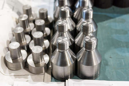 Bolts and screws on a rack in a machine shop.