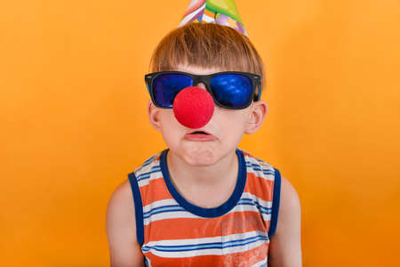 Crazy clown in sunglasses grimaces at the camera.